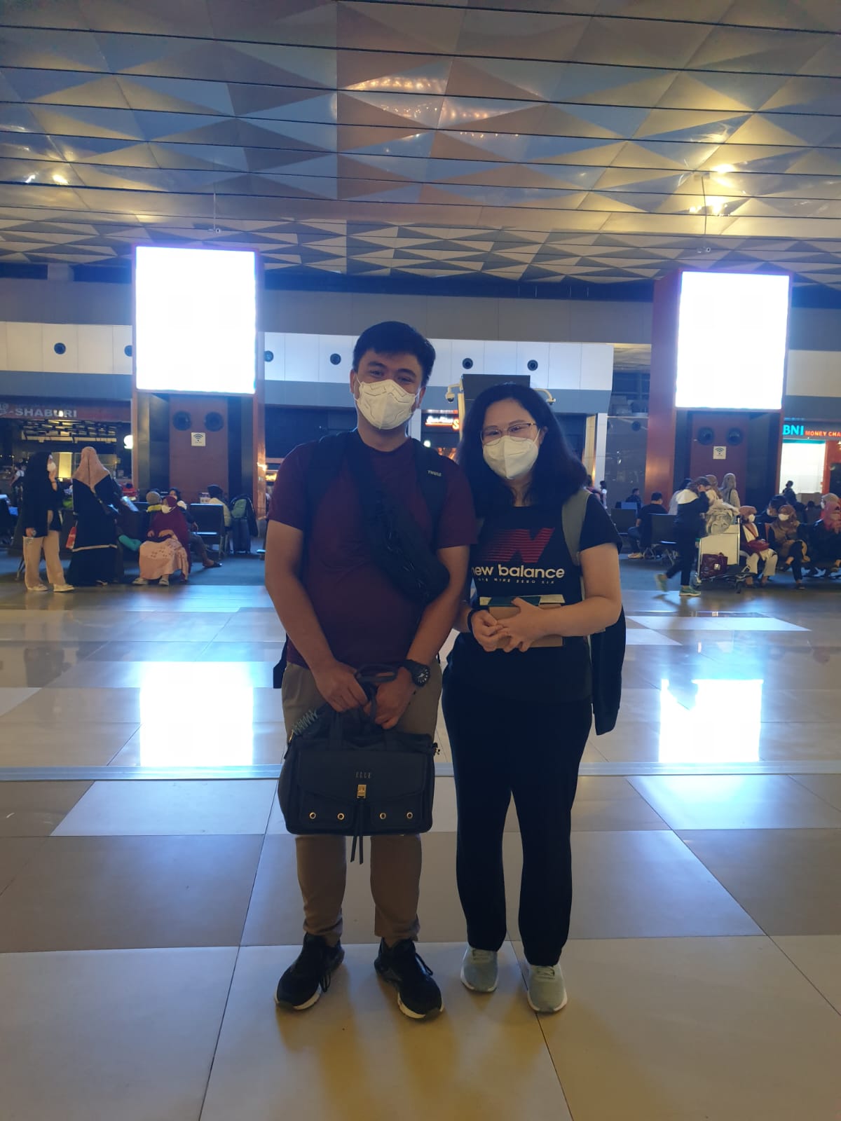 Angelia and Daniel wearing masks at the airport before their first goodbye.