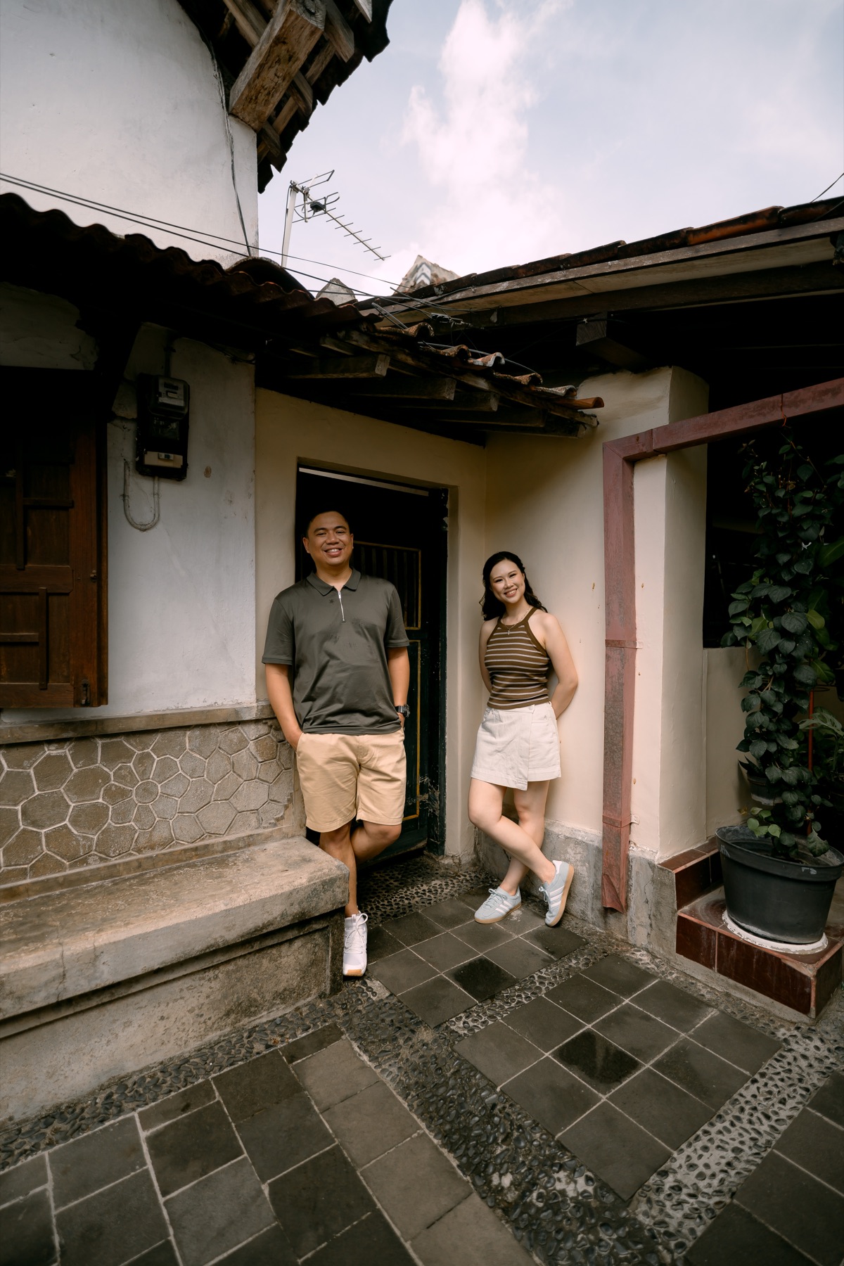 Angelia and Daniel stand together in a quiet courtyard.