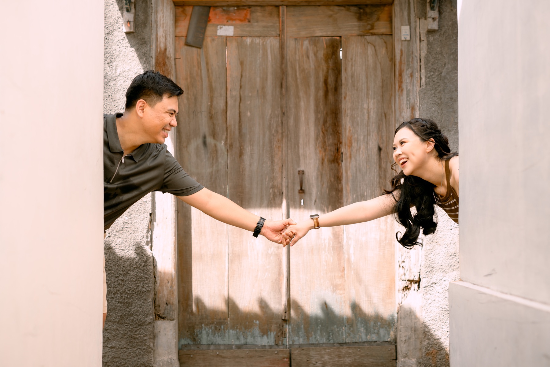 Angelia and Daniel reach for each other across a doorway.