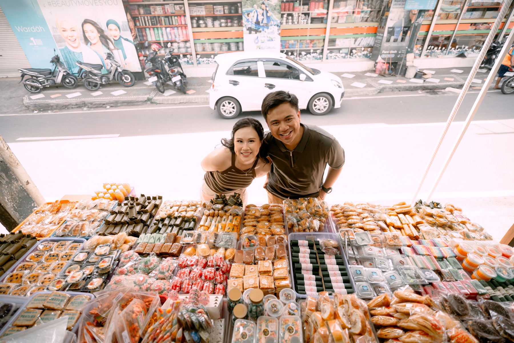 Angelia and Daniel smile across a table of food.