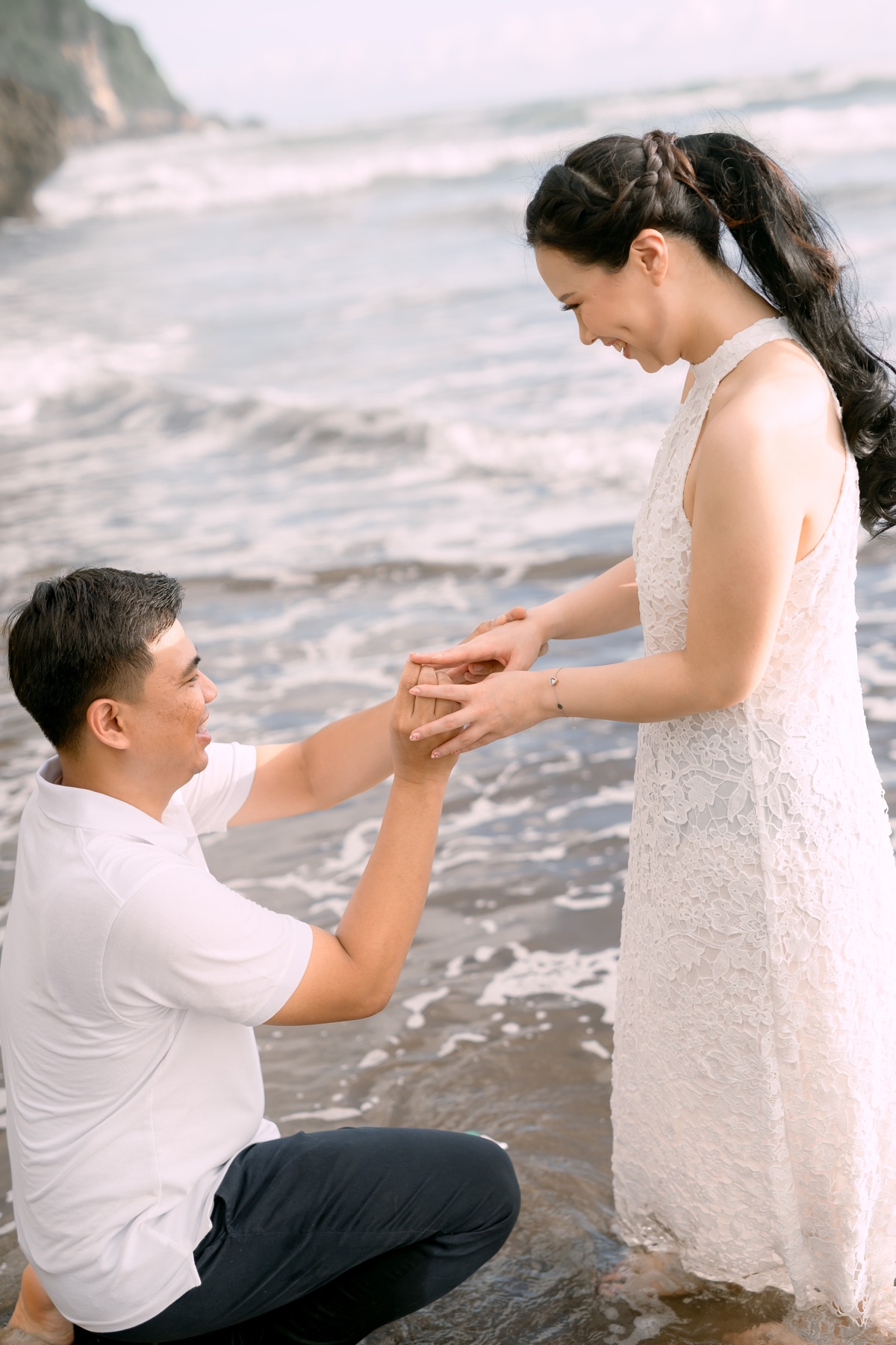 Daniel holds Angelia’s hands beside the sea.