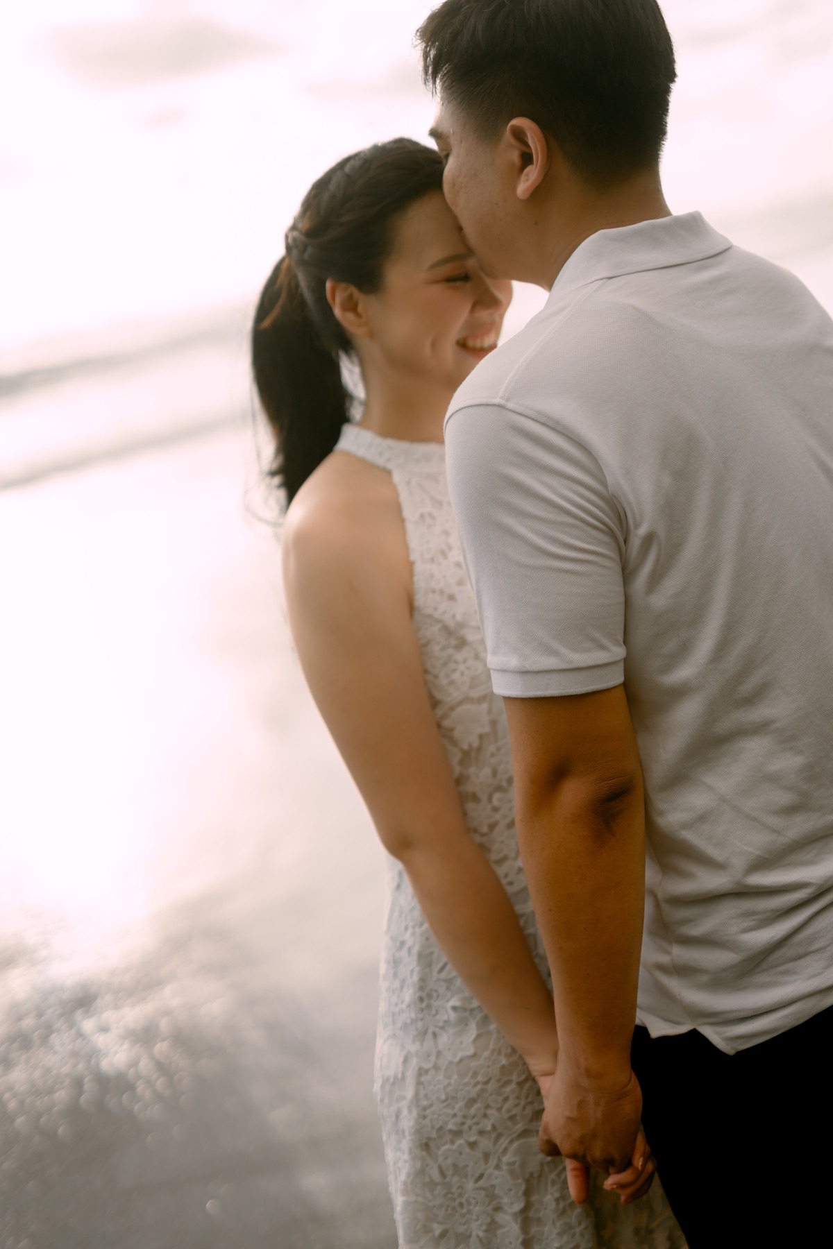 Angelia and Daniel share a quiet embrace by the sea.
